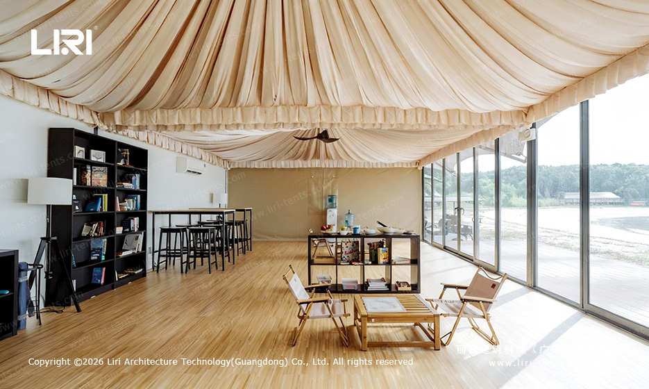 Outdoor BBQ party at Indian-style tent resort — guests dining on beachfront deck, glass door glamping tents behind