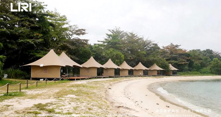 Couple dining on wooden deck of luxury glamping tent — oceanfront dinner, transparent tent sidewalls, beach resort