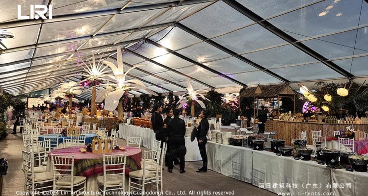 Guests gathered at banquet reception inside clear-span tent with transparent roof