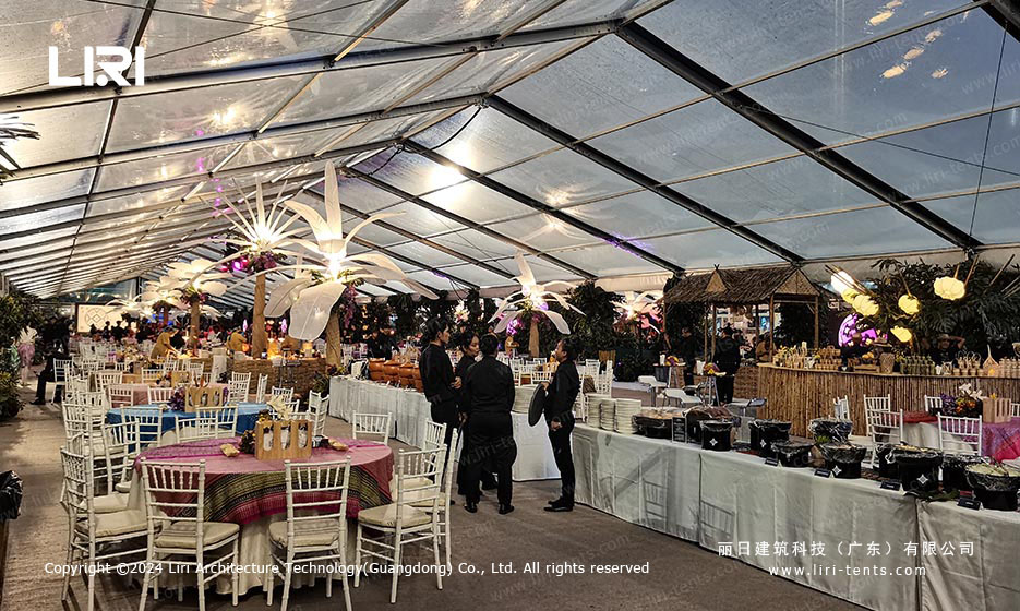 Guests gathered at banquet reception inside clear-span tent with transparent roof