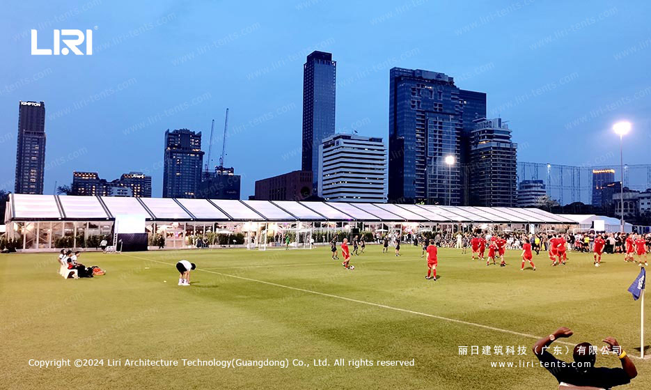 20m clear-span tent with transparent roof installed on urban football field at night