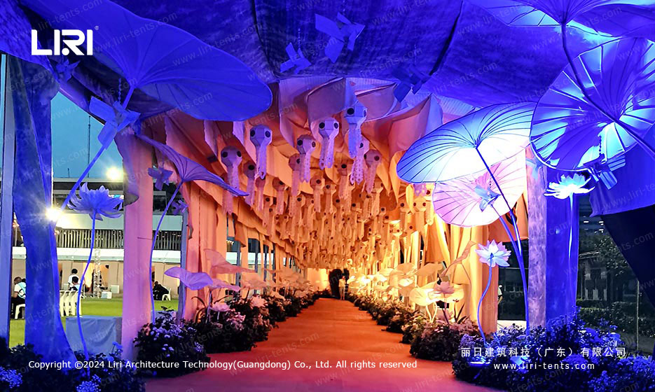 Decorative walkway inside clear-span tent with purple lighting and flower decorations
