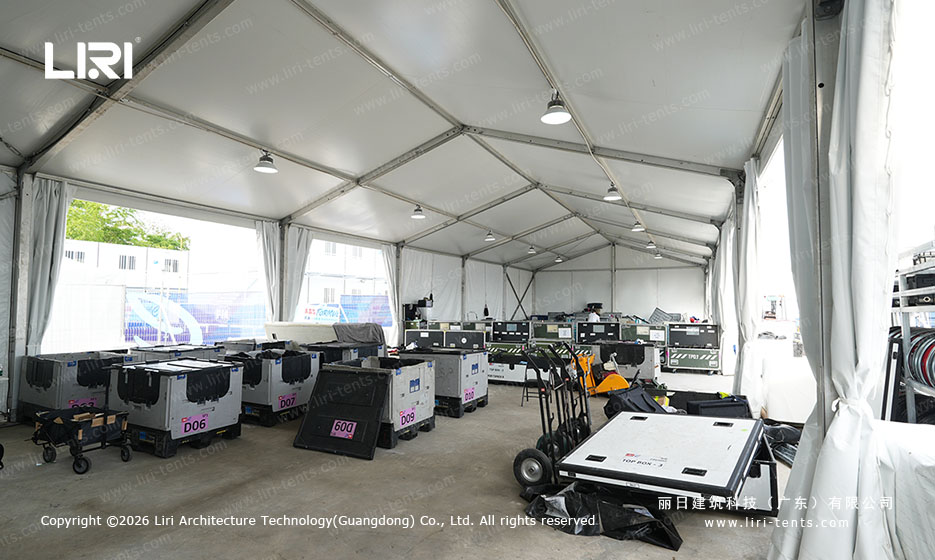 Modular tent interior storing racing equipment flight cases