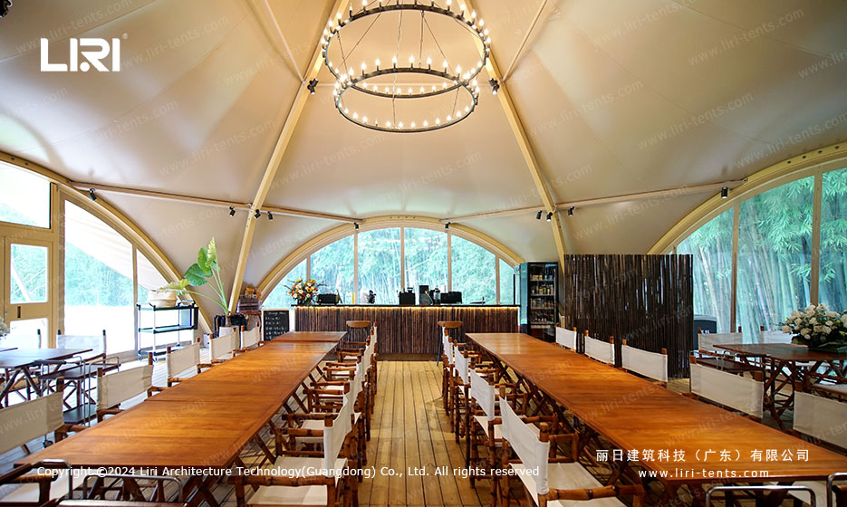 Wedding reception interior of twin-peak tipi tent with bar area and arched ceiling