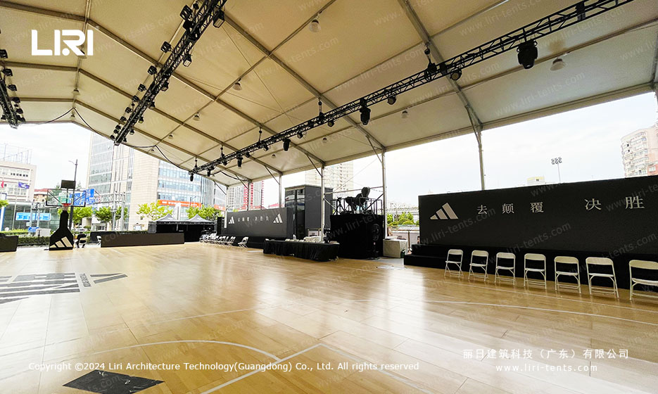 Wedding tent interior with sport stage setup and wooden flooring